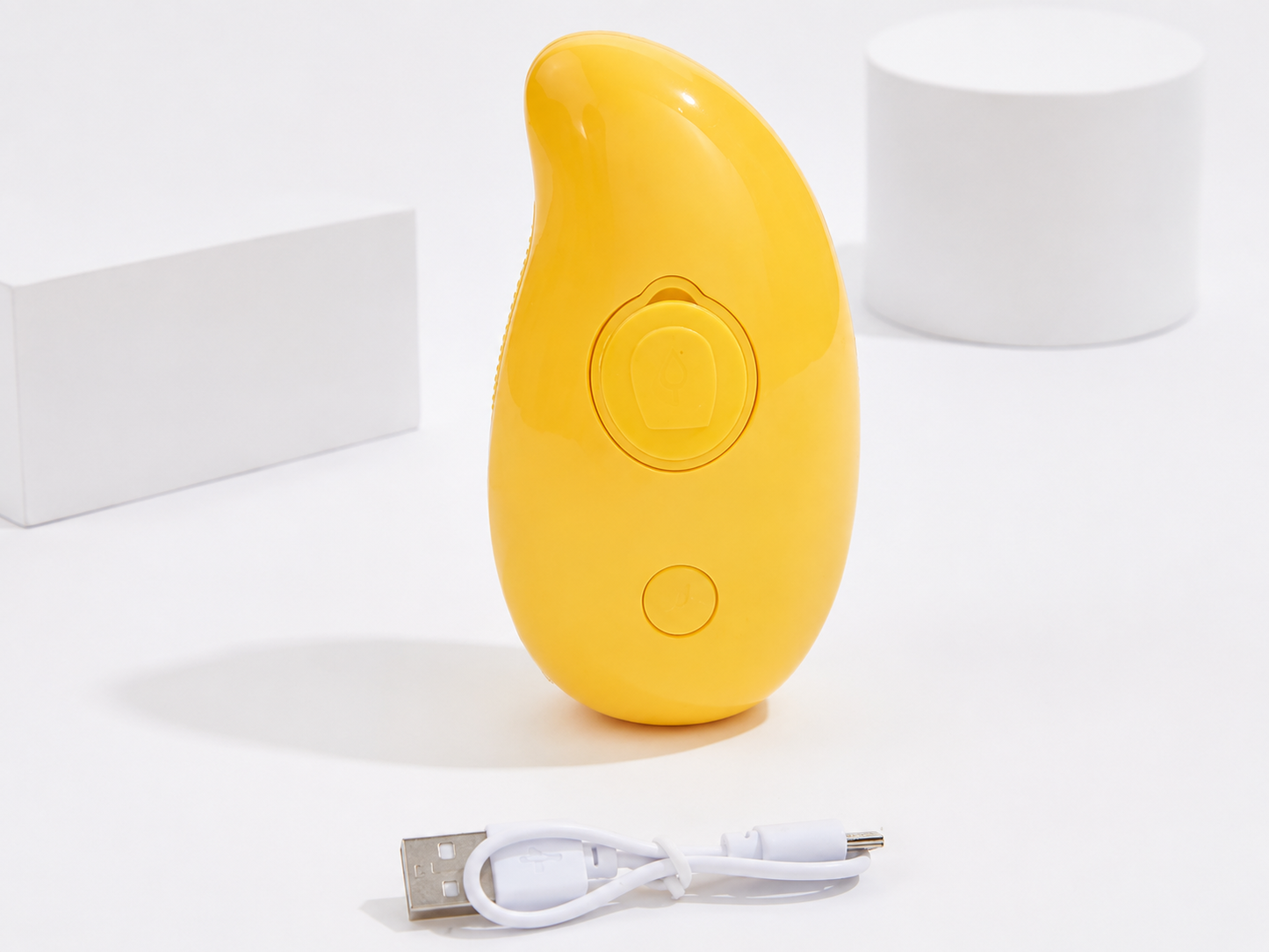 Geel apparaat met USB-kabel voor opladen, ontworpen als SteamyBrush – 3-in-1 Stoom Borstel voor Honden & Katten, ideaal voor het verzorgen van huisdierenvacht.