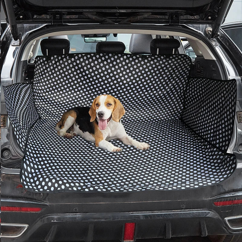 PawLuxe Auto Achterbank Beschermer voor Honden met stippendessin in de achterbak van een auto, waar een tevreden hond op ligt ter bescherming van het interieur tijdens het vervoer.